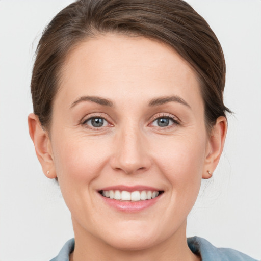 Joyful white young-adult female with short  brown hair and grey eyes