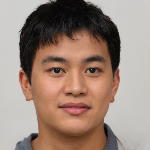 Joyful asian young-adult male with short  brown hair and brown eyes