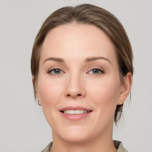 Joyful white young-adult female with medium  brown hair and grey eyes