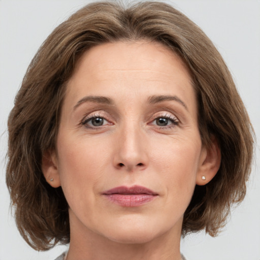 Joyful white adult female with medium  brown hair and grey eyes