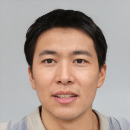 Joyful asian young-adult male with short  black hair and brown eyes