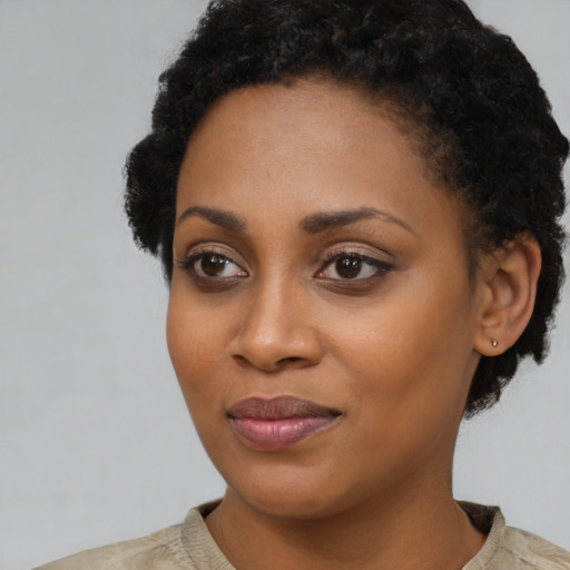 Joyful black young-adult female with short  black hair and brown eyes