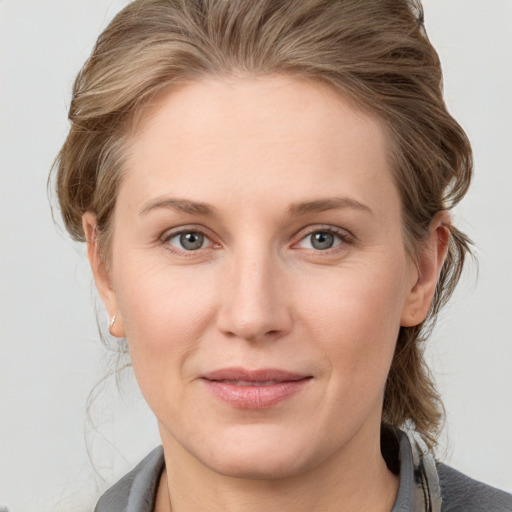 Joyful white young-adult female with medium  brown hair and blue eyes