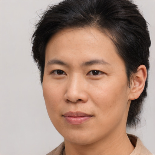 Joyful asian adult female with medium  brown hair and brown eyes