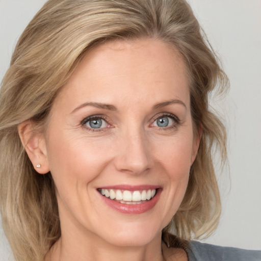 Joyful white adult female with medium  brown hair and blue eyes