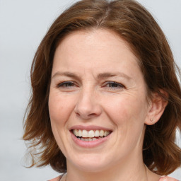 Joyful white adult female with medium  brown hair and blue eyes