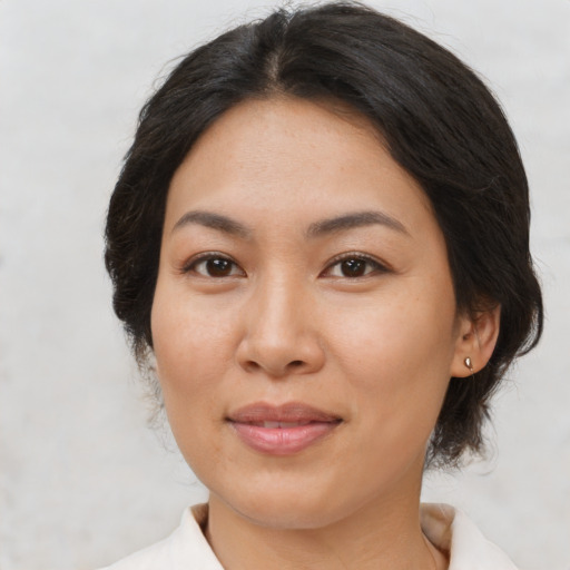 Joyful asian adult female with medium  brown hair and brown eyes
