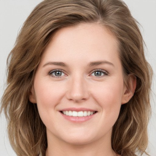 Joyful white young-adult female with long  brown hair and green eyes