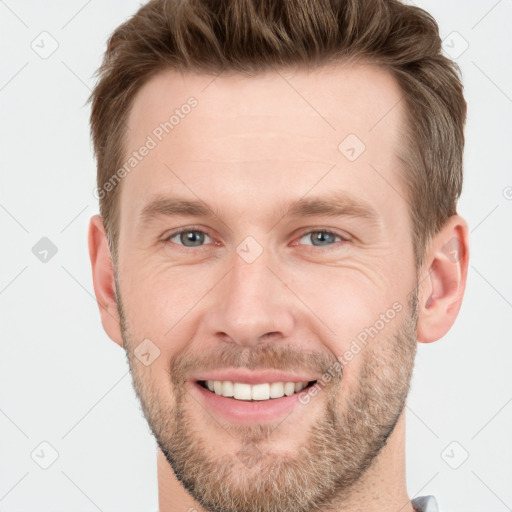 Joyful white young-adult male with short  brown hair and grey eyes