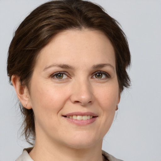 Joyful white young-adult female with medium  brown hair and green eyes