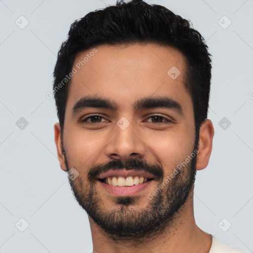 Joyful latino young-adult male with short  black hair and brown eyes