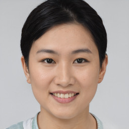 Joyful asian young-adult female with short  brown hair and brown eyes