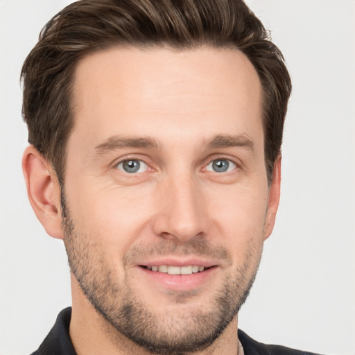 Joyful white young-adult male with short  brown hair and grey eyes