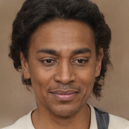 Joyful black adult male with short  brown hair and brown eyes