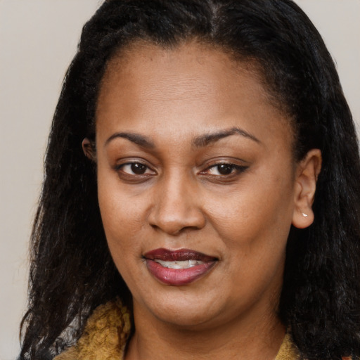 Joyful black adult female with long  brown hair and brown eyes