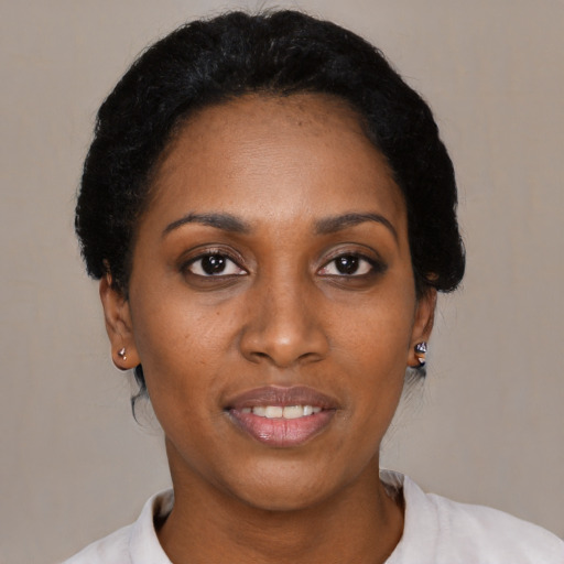 Joyful black young-adult female with short  black hair and brown eyes