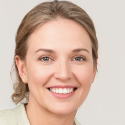 Joyful white young-adult female with medium  brown hair and grey eyes