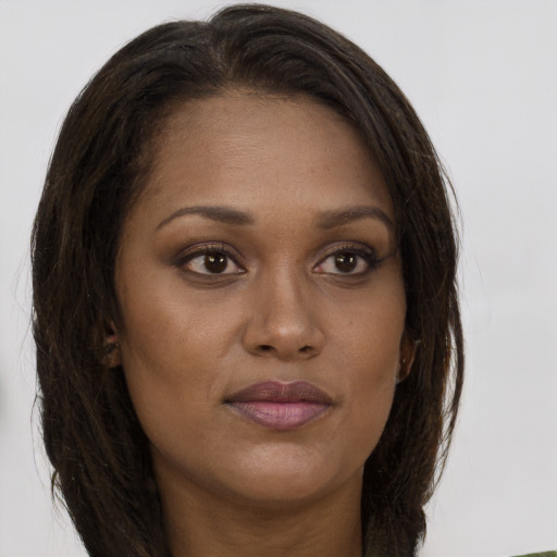 Joyful black young-adult female with long  brown hair and brown eyes