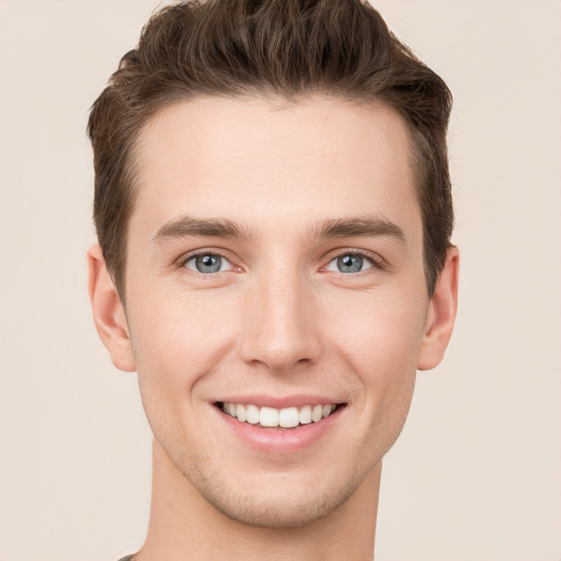 Joyful white young-adult male with short  brown hair and grey eyes