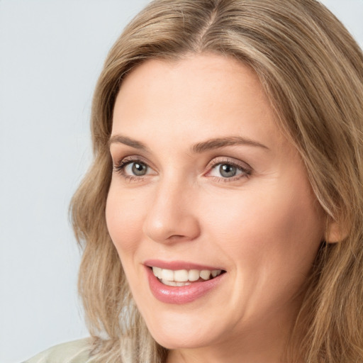 Joyful white young-adult female with long  brown hair and green eyes