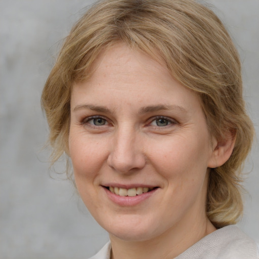 Joyful white young-adult female with medium  brown hair and blue eyes