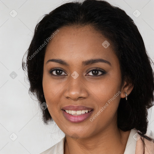 Joyful black young-adult female with long  black hair and brown eyes