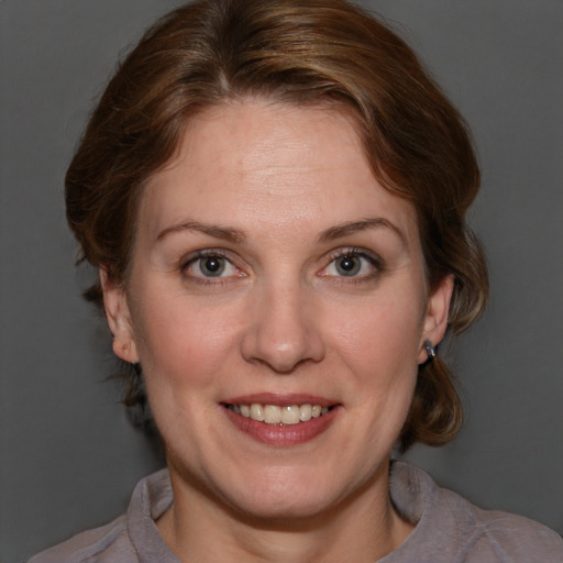 Joyful white adult female with medium  brown hair and blue eyes