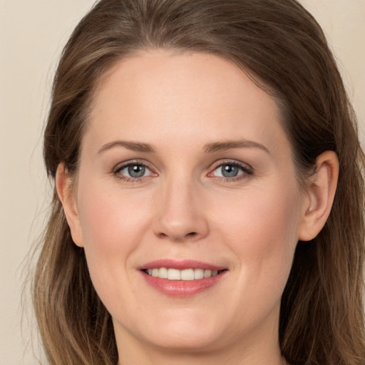 Joyful white young-adult female with long  brown hair and grey eyes