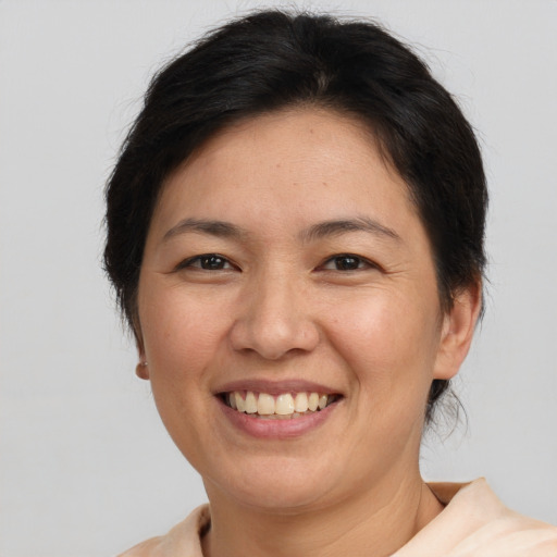 Joyful asian adult female with short  brown hair and brown eyes