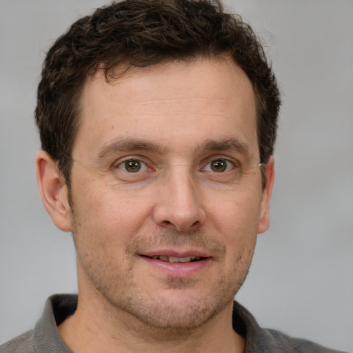 Joyful white adult male with short  brown hair and grey eyes