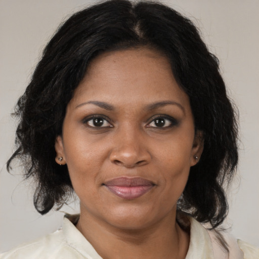 Joyful black adult female with medium  brown hair and brown eyes