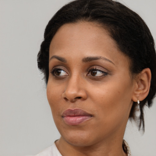 Joyful black young-adult female with medium  brown hair and brown eyes