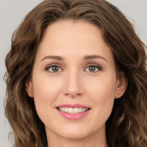 Joyful white young-adult female with long  brown hair and green eyes