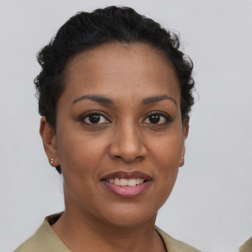 Joyful black young-adult female with short  brown hair and brown eyes
