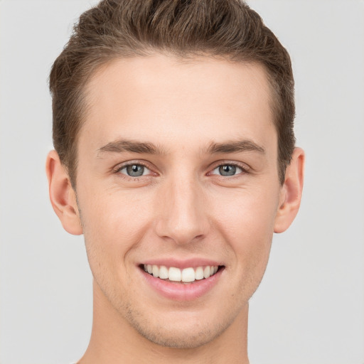 Joyful white young-adult male with short  brown hair and grey eyes