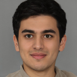 Joyful latino young-adult male with short  brown hair and brown eyes