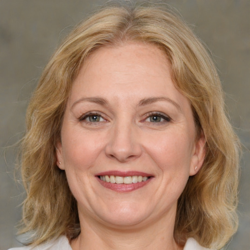 Joyful white adult female with medium  brown hair and green eyes