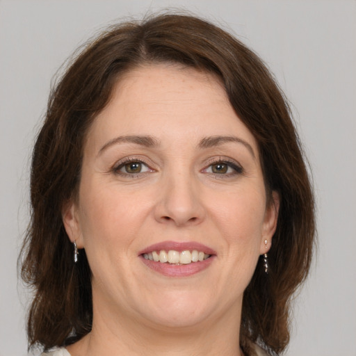 Joyful white adult female with medium  brown hair and grey eyes