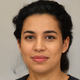 Joyful latino young-adult female with medium  brown hair and brown eyes