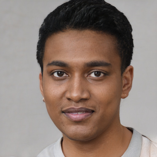 Joyful black young-adult male with short  black hair and brown eyes
