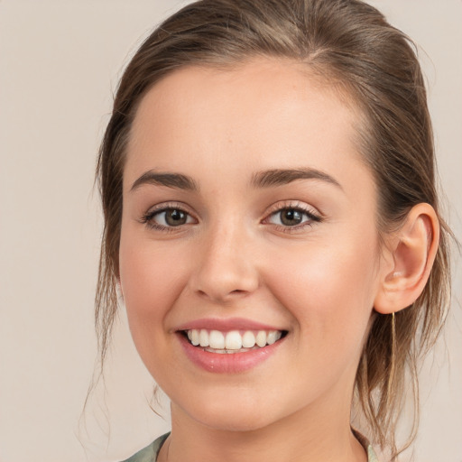 Joyful white young-adult female with long  brown hair and grey eyes