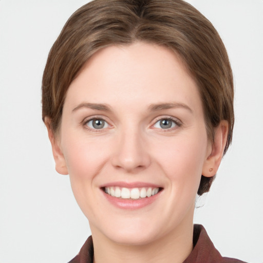 Joyful white young-adult female with short  brown hair and grey eyes