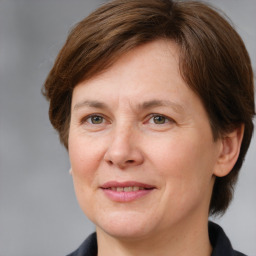 Joyful white adult female with medium  brown hair and grey eyes