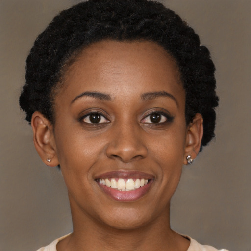 Joyful black young-adult female with short  brown hair and brown eyes