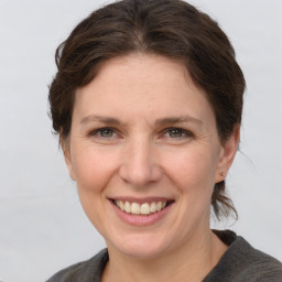 Joyful white adult female with medium  brown hair and grey eyes