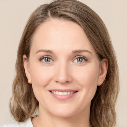 Joyful white young-adult female with medium  brown hair and green eyes