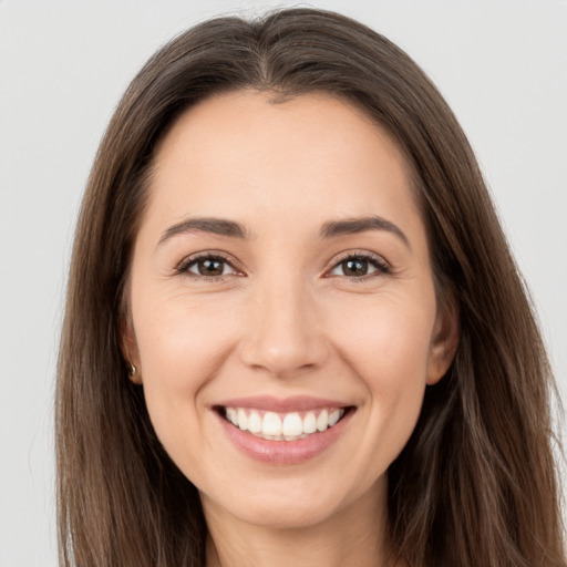 Joyful white young-adult female with long  brown hair and brown eyes