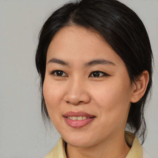Joyful asian adult female with medium  brown hair and brown eyes