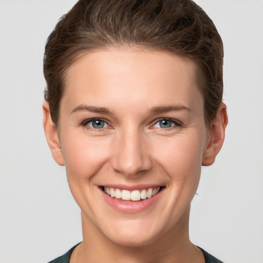 Joyful white young-adult female with short  brown hair and grey eyes