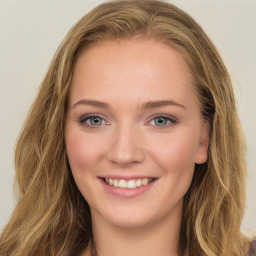 Joyful white young-adult female with long  brown hair and green eyes